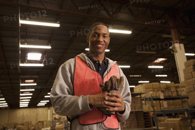 Black man in reflector-vest in warehouse