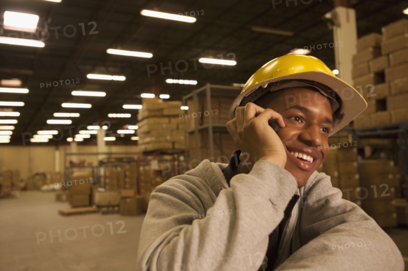 Black man talking on cell phone in warehouse