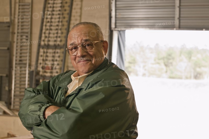 Mixed race man with arms crossed in warehouse