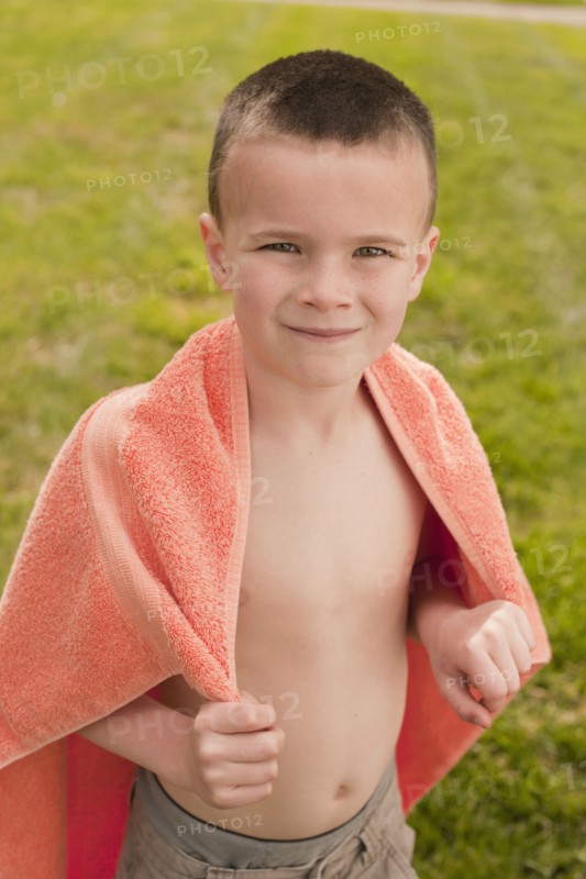 Caucasian boy wrapped in towel