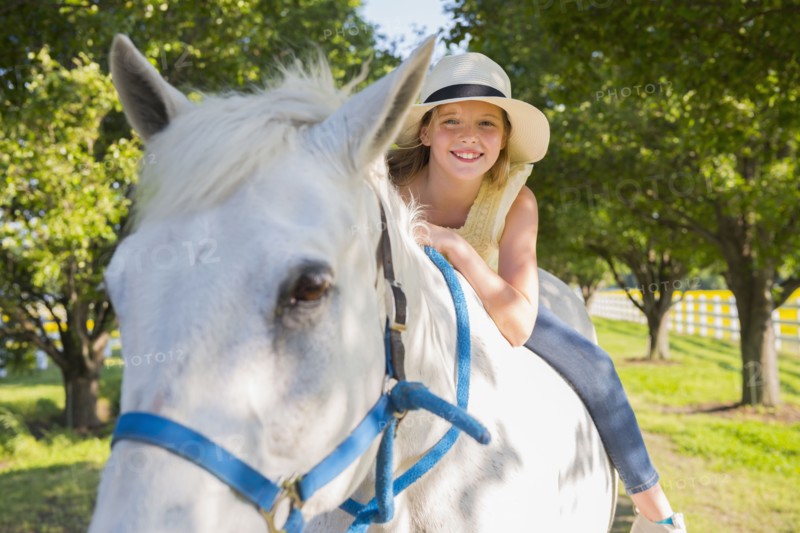 Caucasian girl riding horse on dirt path
