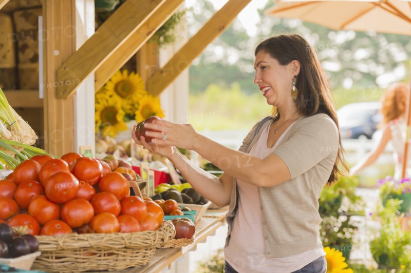 Hispanic woman browsing fruit at farmers market