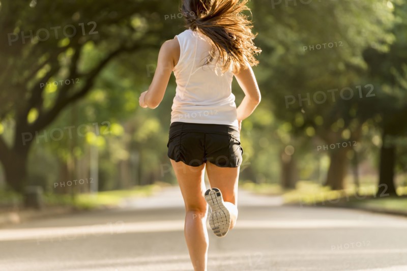 Caucasian woman jogging on neighborhood street