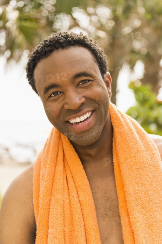 Black man wearing towel on beach