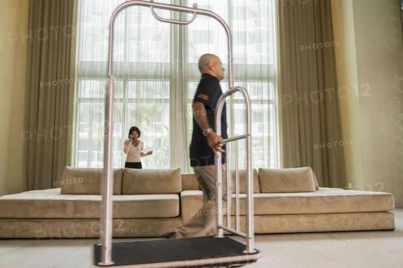 Bellhop pulling cart in hotel lobby