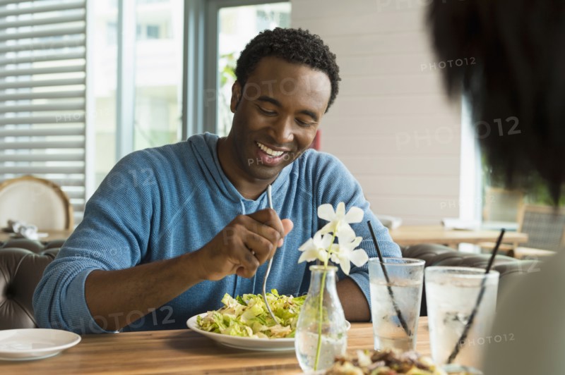 Black man eating breakfast in cafe
