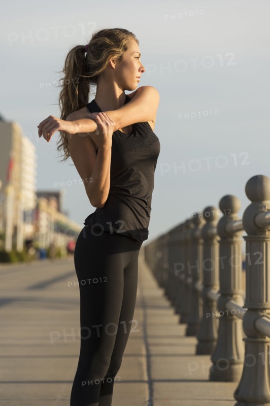 Caucasian teenage girl stretching arm on boardwalk
