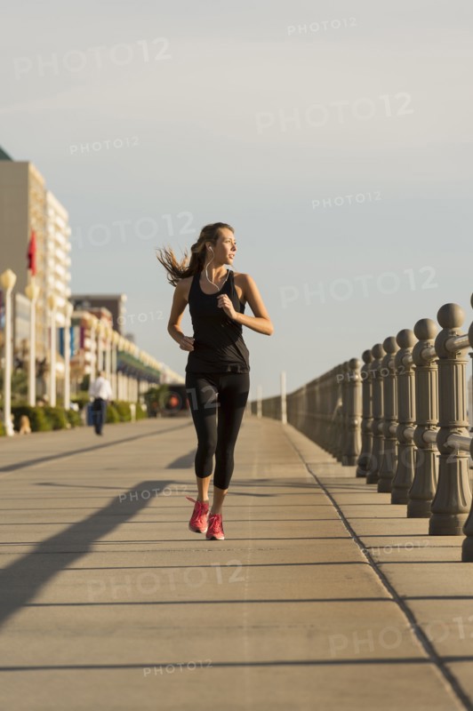 Caucasian teenage girl running on boardwalk