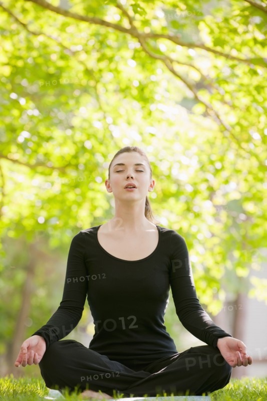 Caucasian woman practicing yoga in park