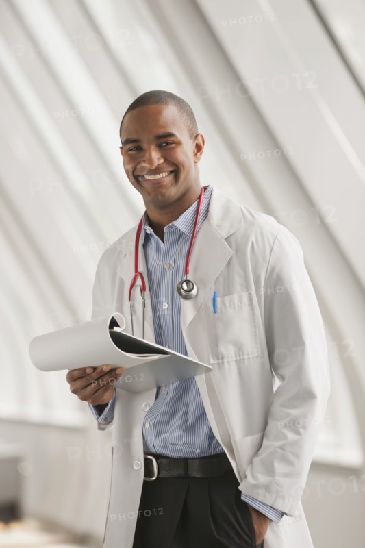 Smiling Black doctor standing with hands in pockets