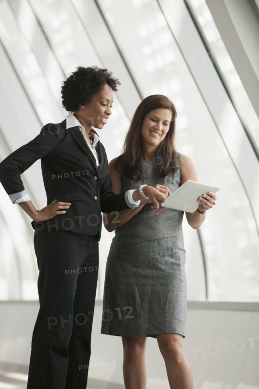 Businesswomen using digital tablet together