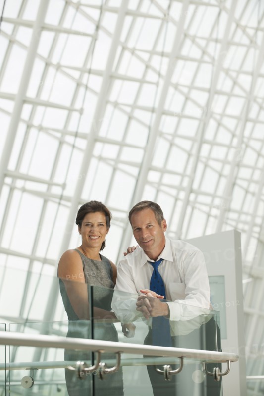 Business people leaning on railing