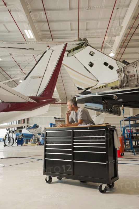 Caucasian man working in airplane hangar