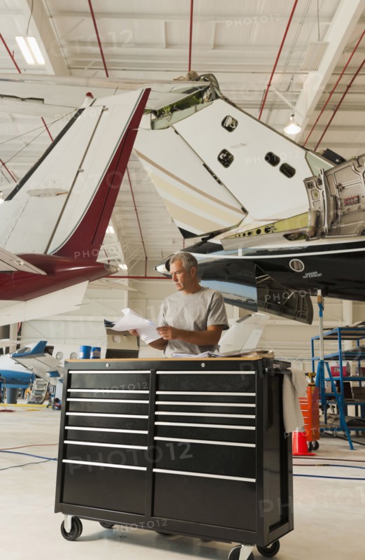 Caucasian man working in airplane hangar