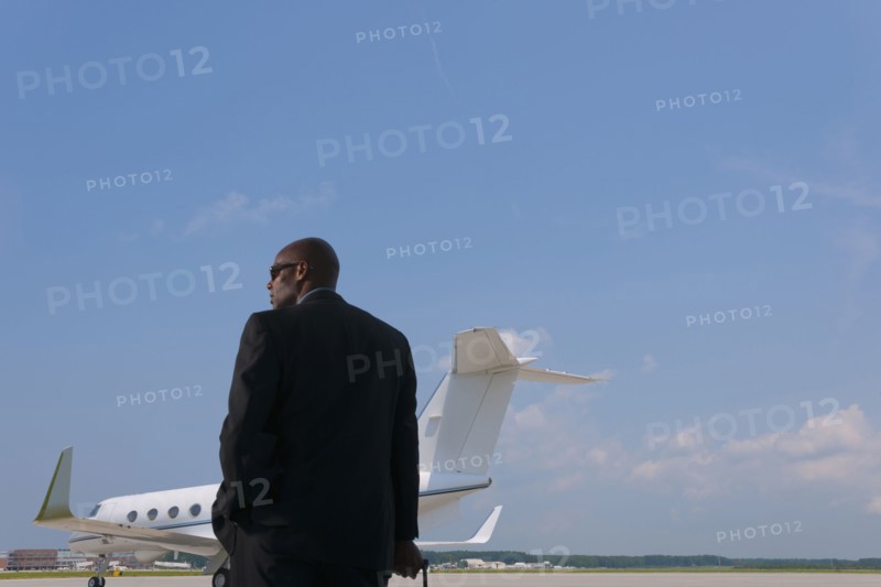 African American businessman standing on airport tarmac