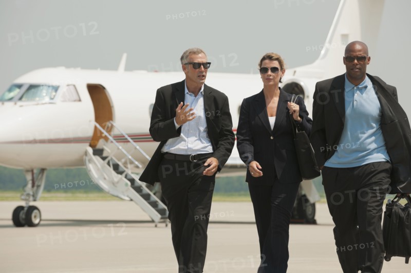 Business people walking on airport tarmac