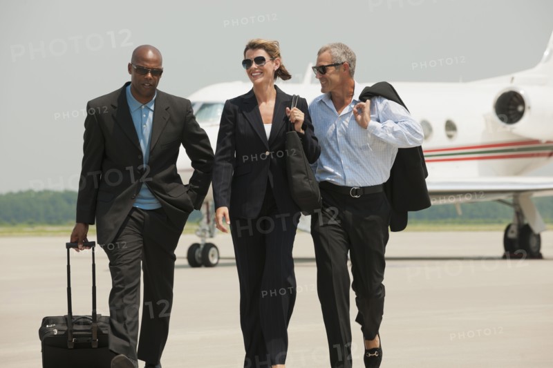 Business people walking on airport tarmac