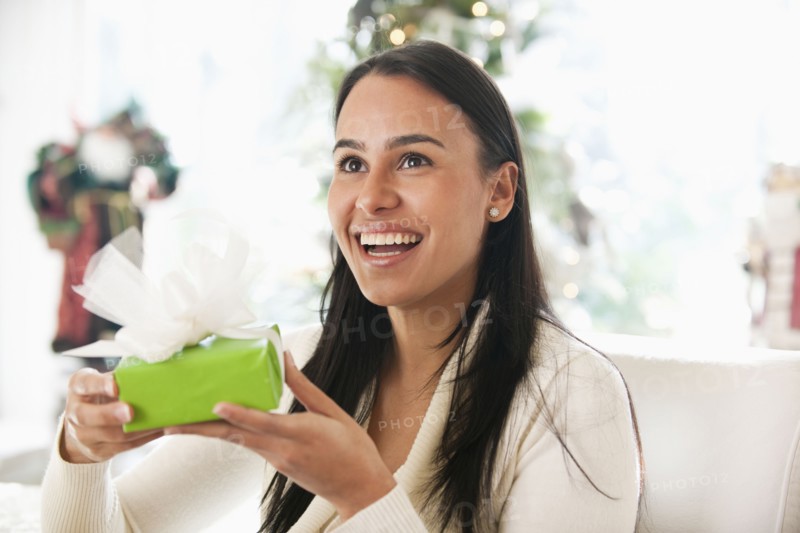 Hispanic woman holding Christmas gift