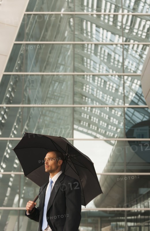 Caucasian businessman underneath umbrella