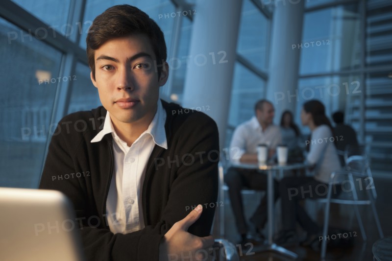Mixed race businessman using laptop in cafe