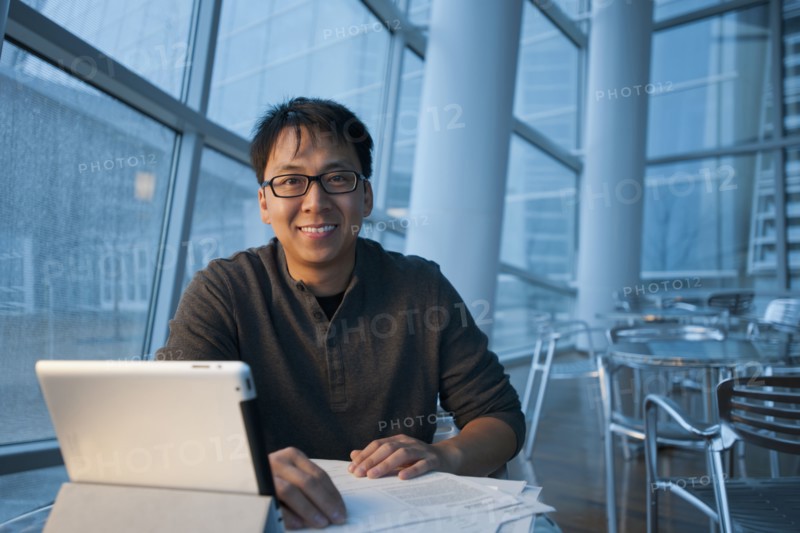 Asian businessman working with digital tablet in cafe