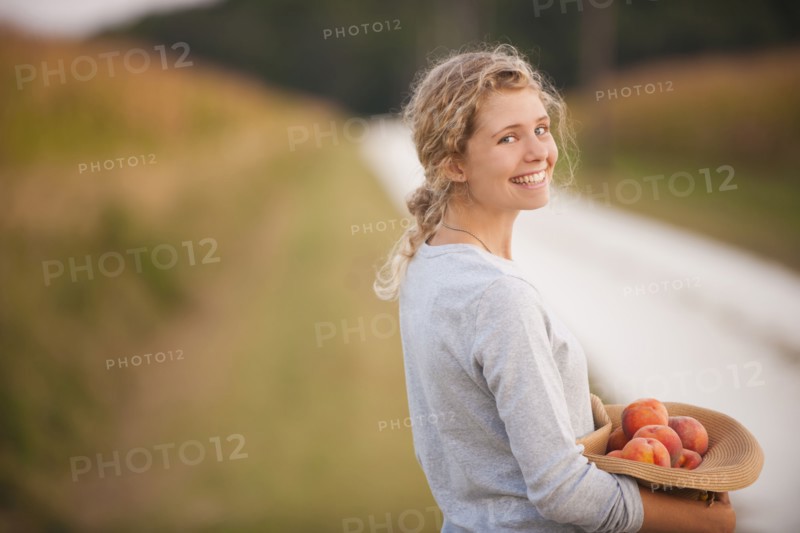 Caucasian woman picking fruit on rural road
