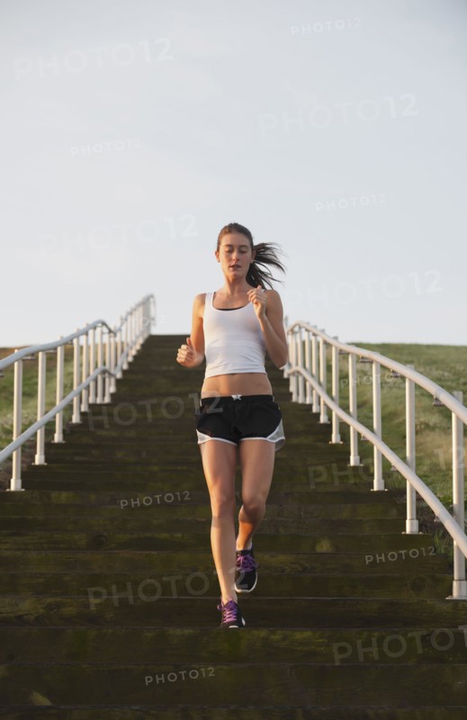 Caucasian woman running down steps