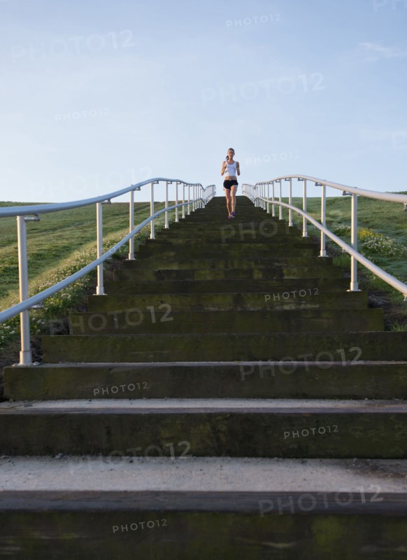 Caucasian woman running up steps