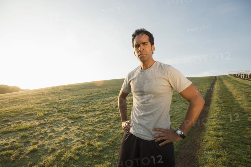 Mixed race runner standing in field