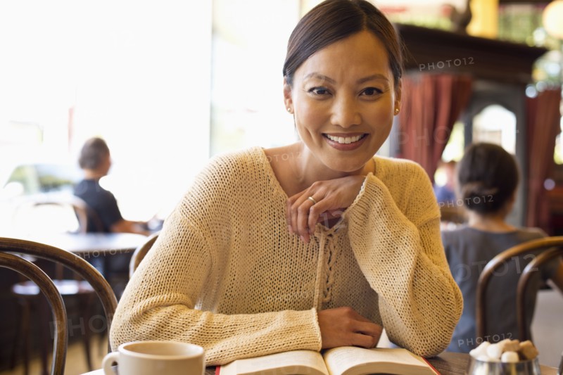 Filipino woman reading book in cafe