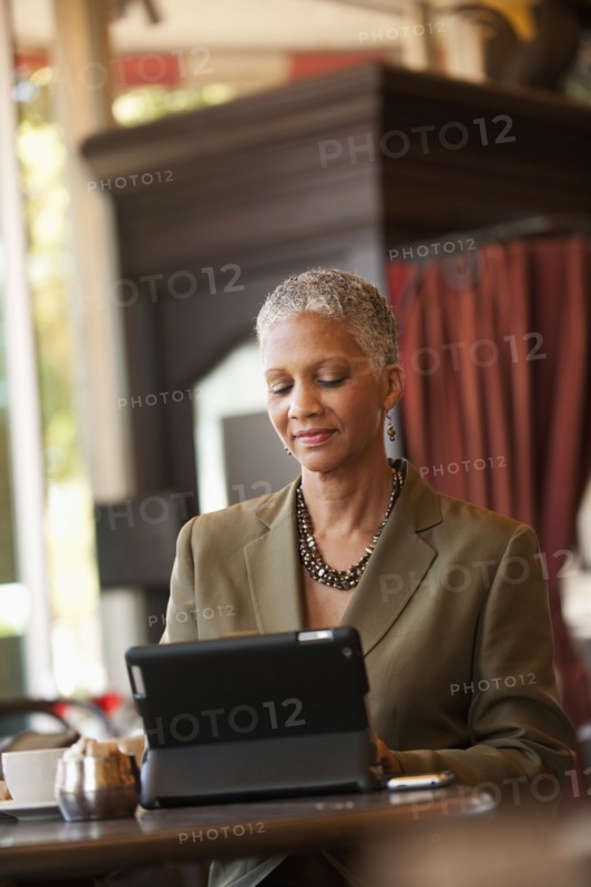 African American businesswoman using digital tablet in cafe