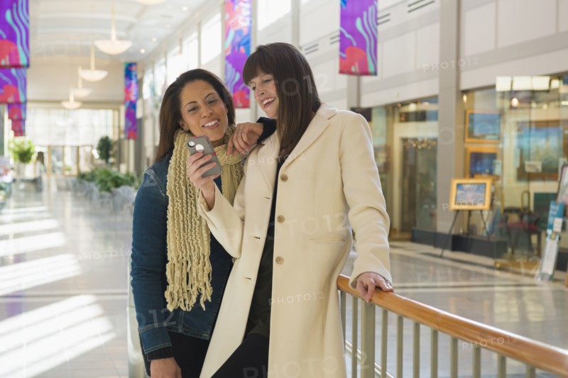 Women using cell phone in shopping mall