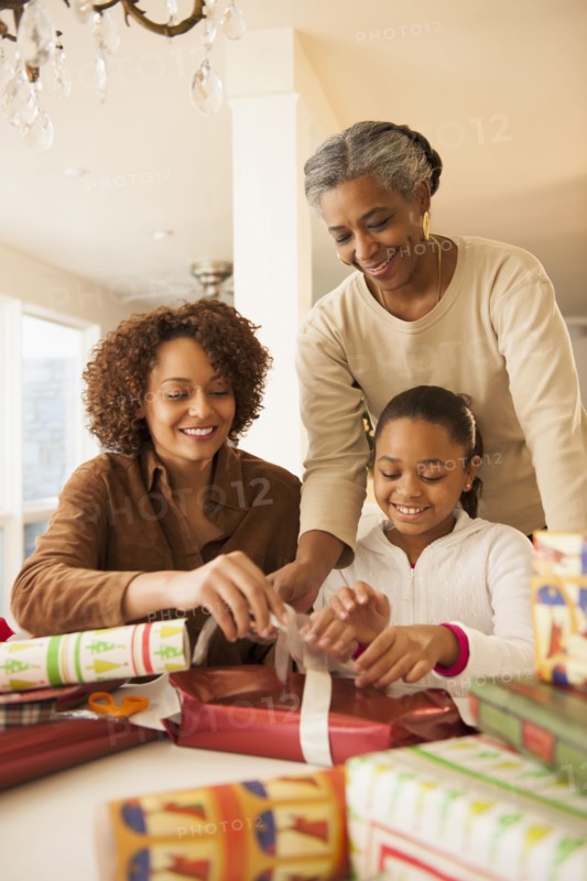 Three generations of women wrapping Christmas presents
