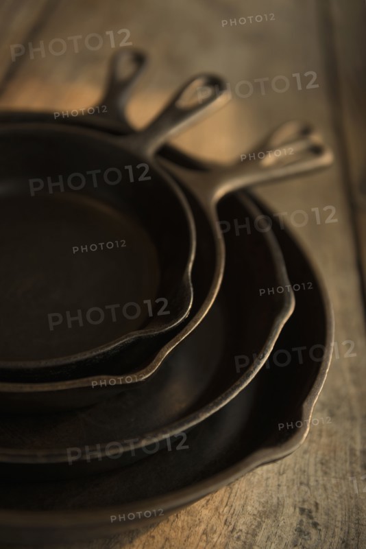 Empty cast iron pans on wooden board