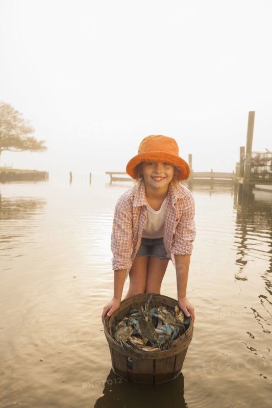 Caucasian girl holding basket of crabs