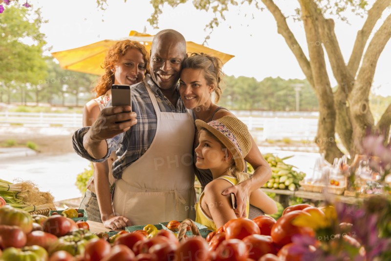 Family taking cell phone selfie at farmers market