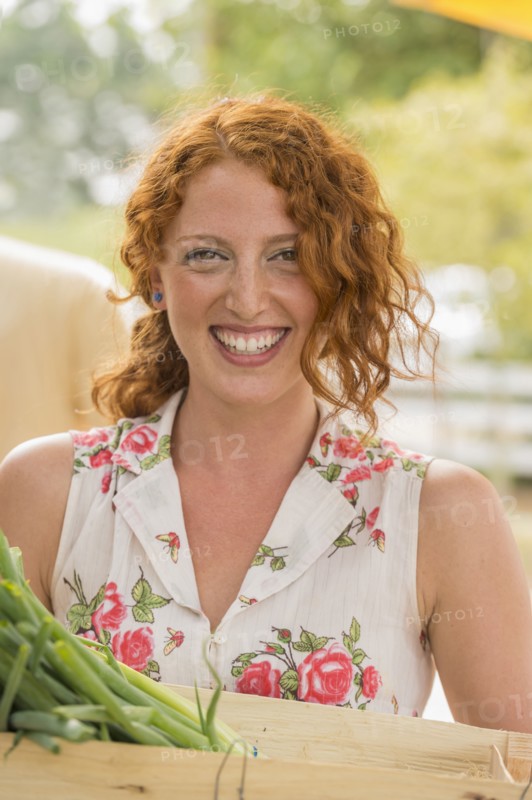 Caucasian woman carrying crate of produce