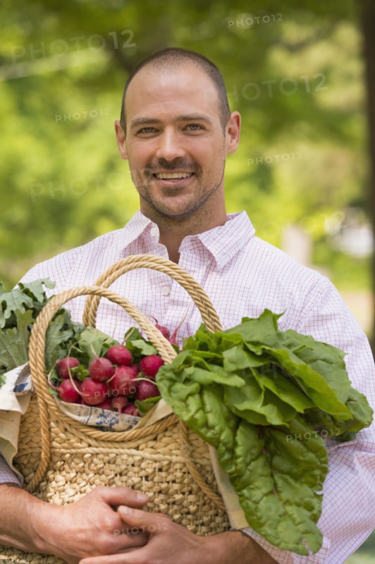 Caucasian man carrying basket of fresh produce