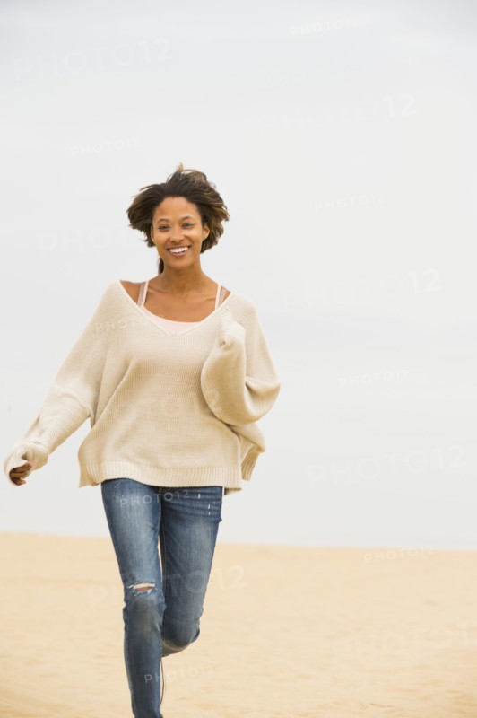 African American woman running on beach