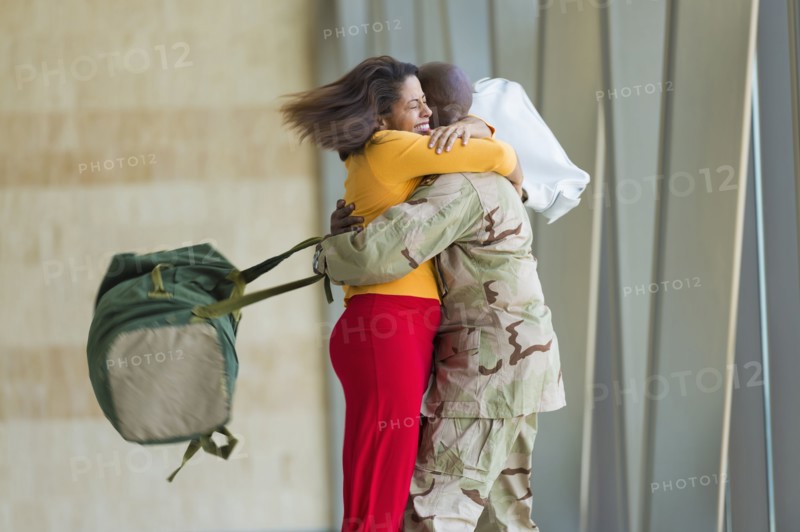 African American soldier hugging wife in airport