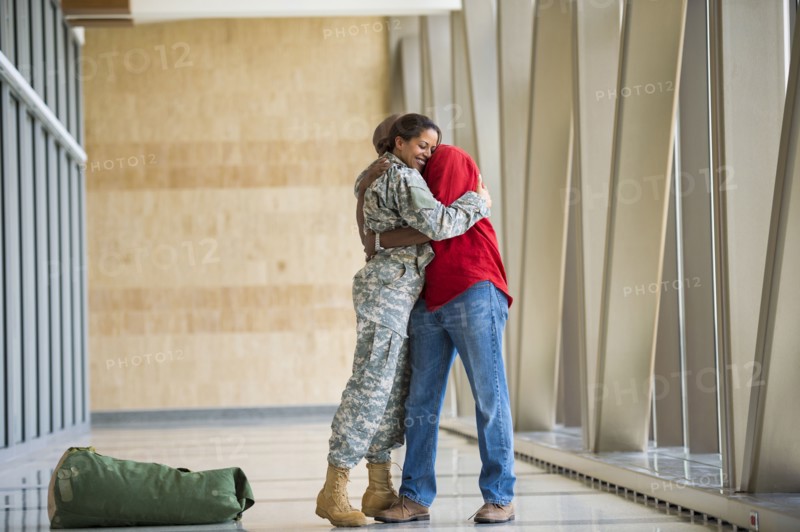 African American soldier hugging husband in airport