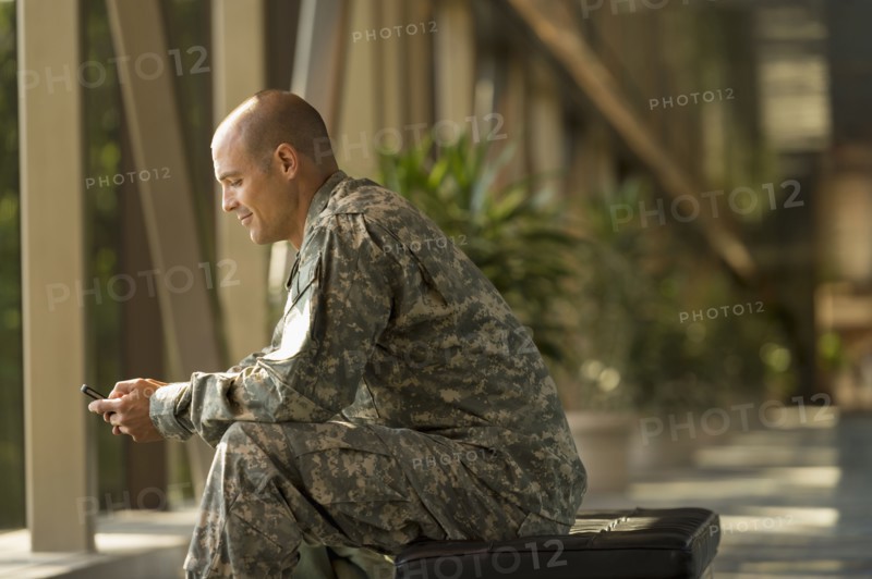 Caucasian soldier using cell phone in airport