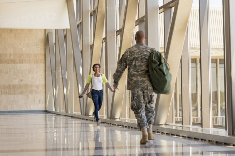 Returning soldier greeting girlfriend in airport
