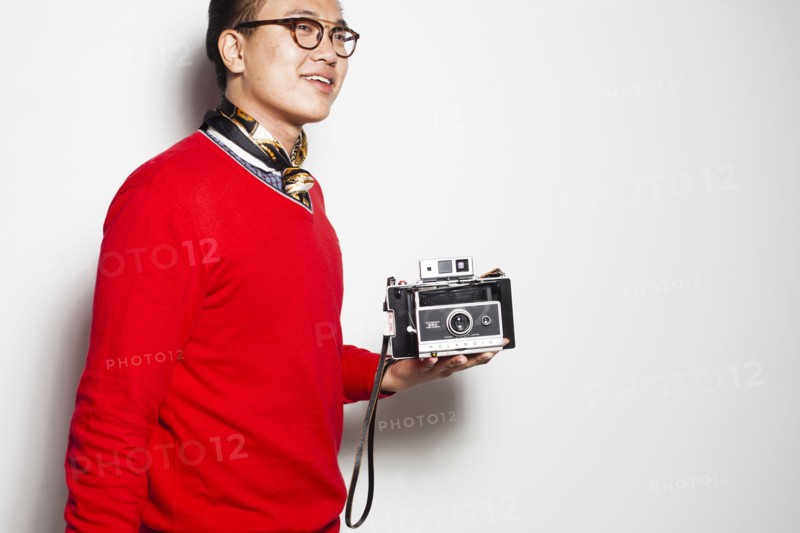 Asian photographer holding vintage camera