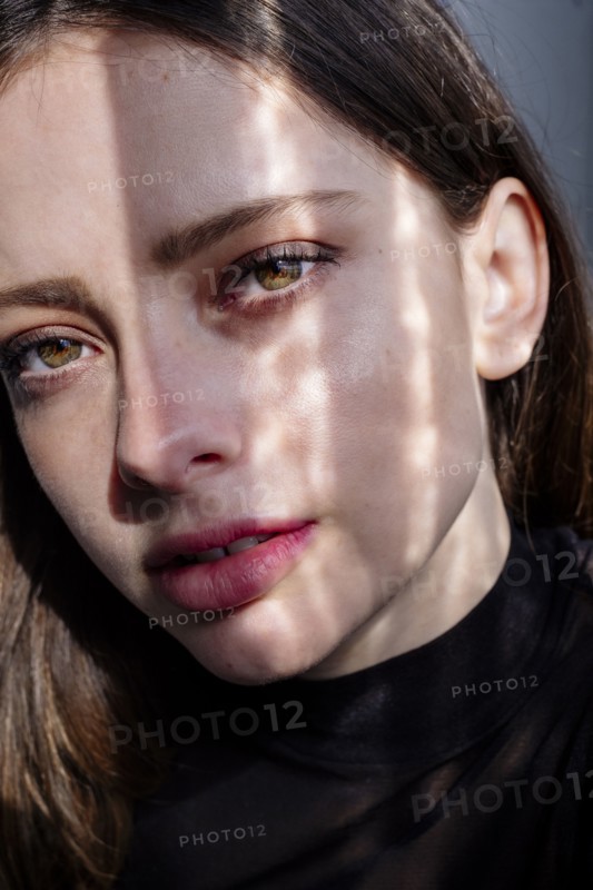 Shadow on face of serious Caucasian woman