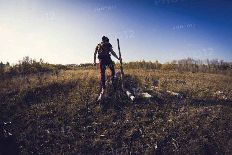 Man walking on log in field