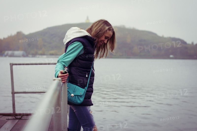 Caucasian woman standing on dock over still lake