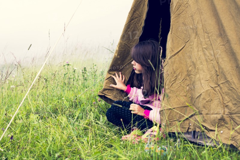 Caucasian girl sitting in camp tent