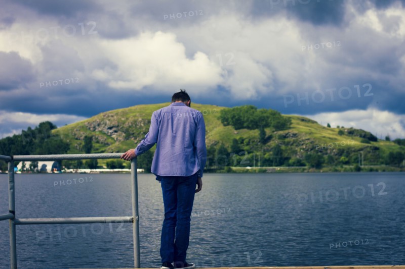 Caucasian man standing on dock at lake
