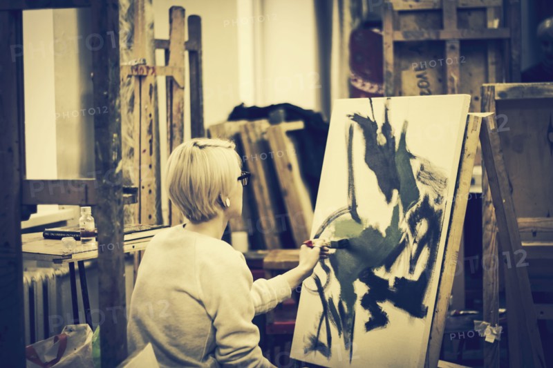 Caucasian artist painting on canvas in studio